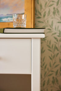 Closeup of a one drawer nightstand finished with a white Benjamin Moore paint color.