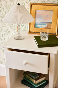 Closeup of a one drawer nightstand finished with a white Benjamin Moore paint color.