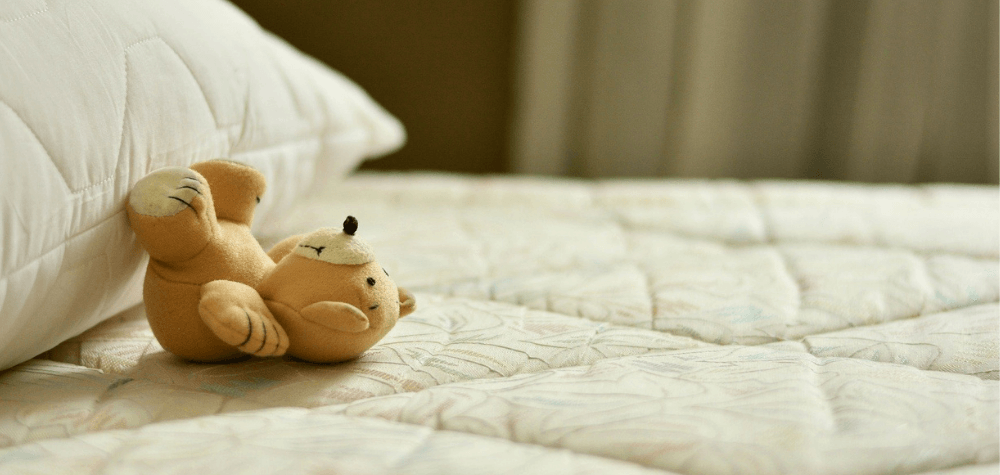 A teddy bear on a mattress